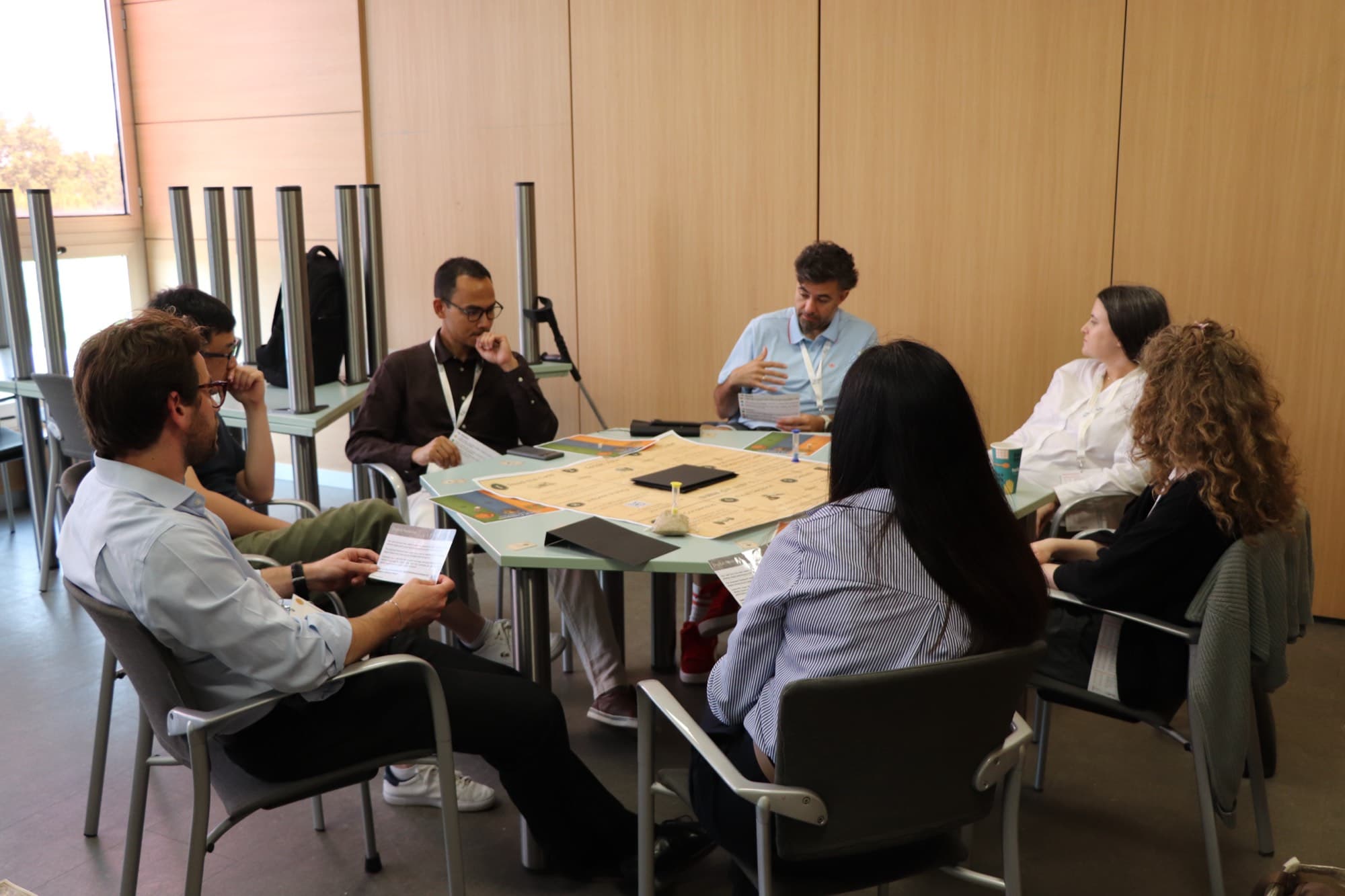 Conference delegates around a table playing ethixCube at EU-SPRI in Valencia